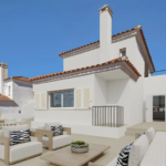 Modern exterior of an Olimpo Mijas villa with outdoor seating and a sunny terrace.