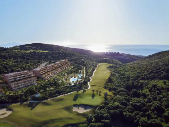 Sunset view of Atria F1 residences with golf course and sea in the background