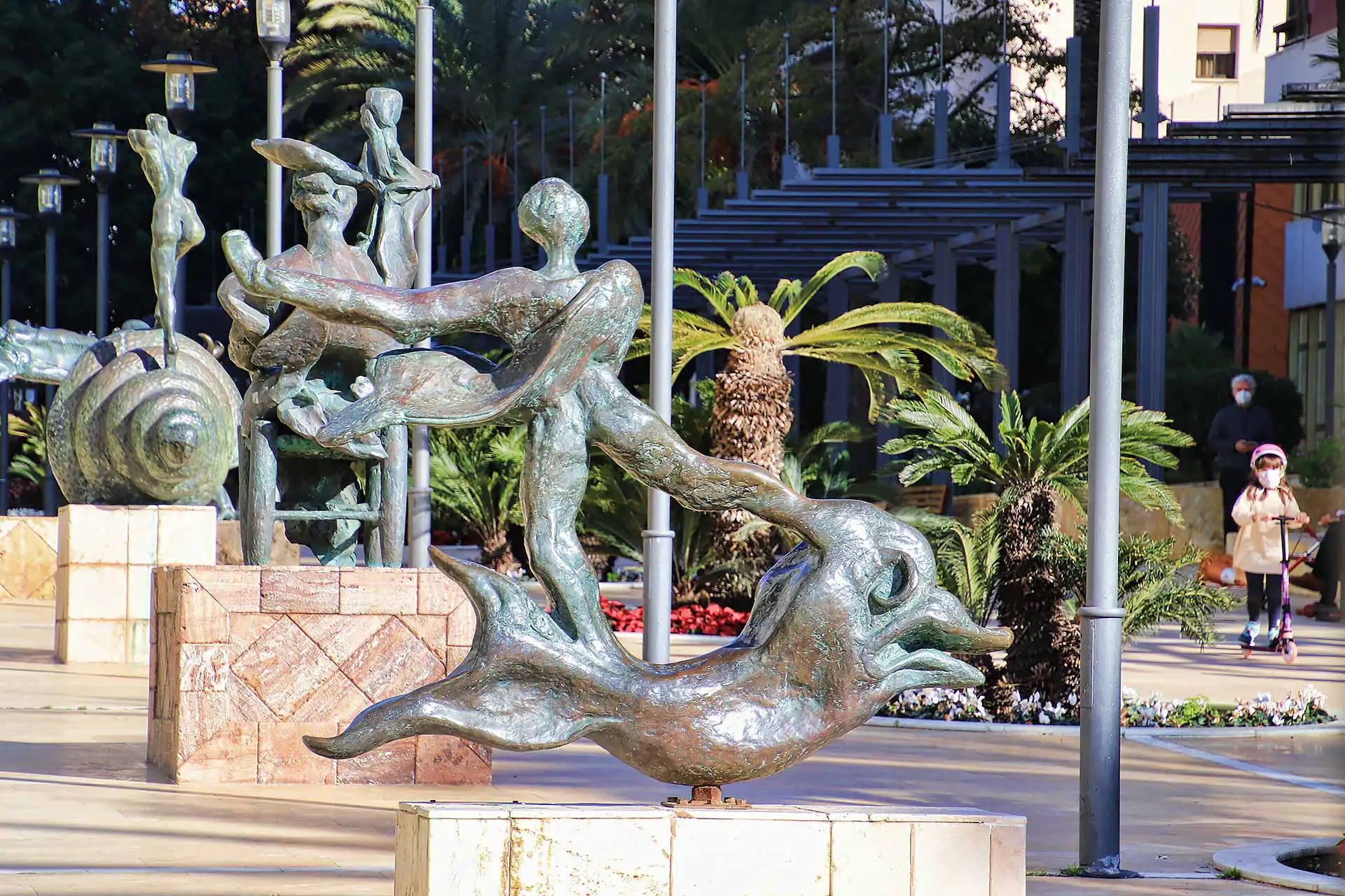 Salvador Dalí sculptures on Avenida del Mar in Marbella, surrounded by lush greenery and palm trees.
