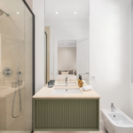 Modern bathroom with walk-in shower, floating vanity, and window at Villa Valora