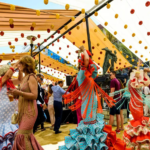 People dancing and celebrating under festive decorations at Marbella San Bernabe