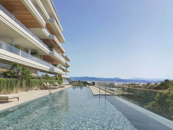 Outdoor infinity pool with lounge chairs and panoramic views at Kosmos Fuengirola