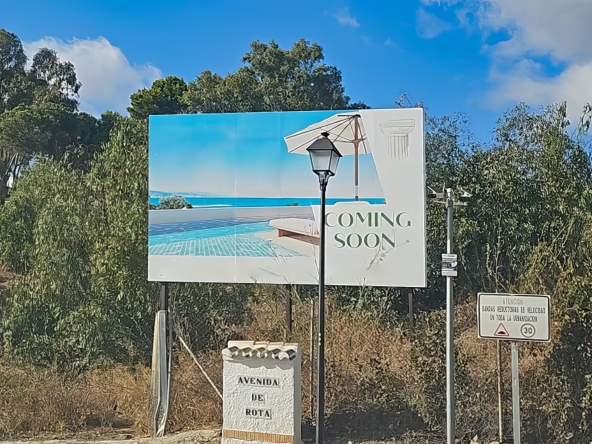 Billboard announcing new real estate development coming soon to Avenida del Rota, Torrenueva, Mijas, with a pool and sea view illustration.