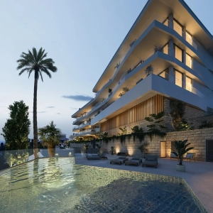 A modern residential building featuring a pool and palm trees in the foreground.