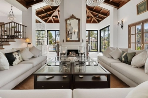 Modern living room featuring white sofas, a glass coffee table, and a wooden ceiling.