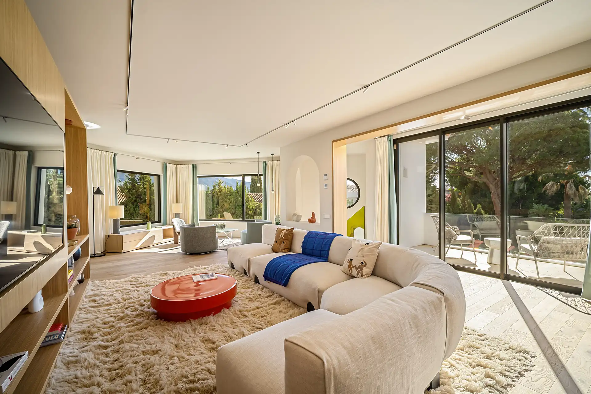 Villa Madrisa spacious modern living room featuring a sectional sofa, coffee table, and large windows with natural light.