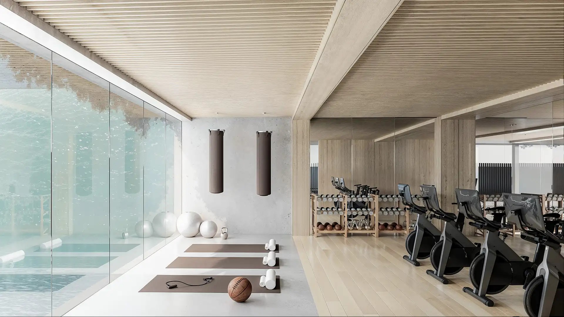 Interior view of a modern fitness studio featuring exercise mats, weights, and cardio equipment.
