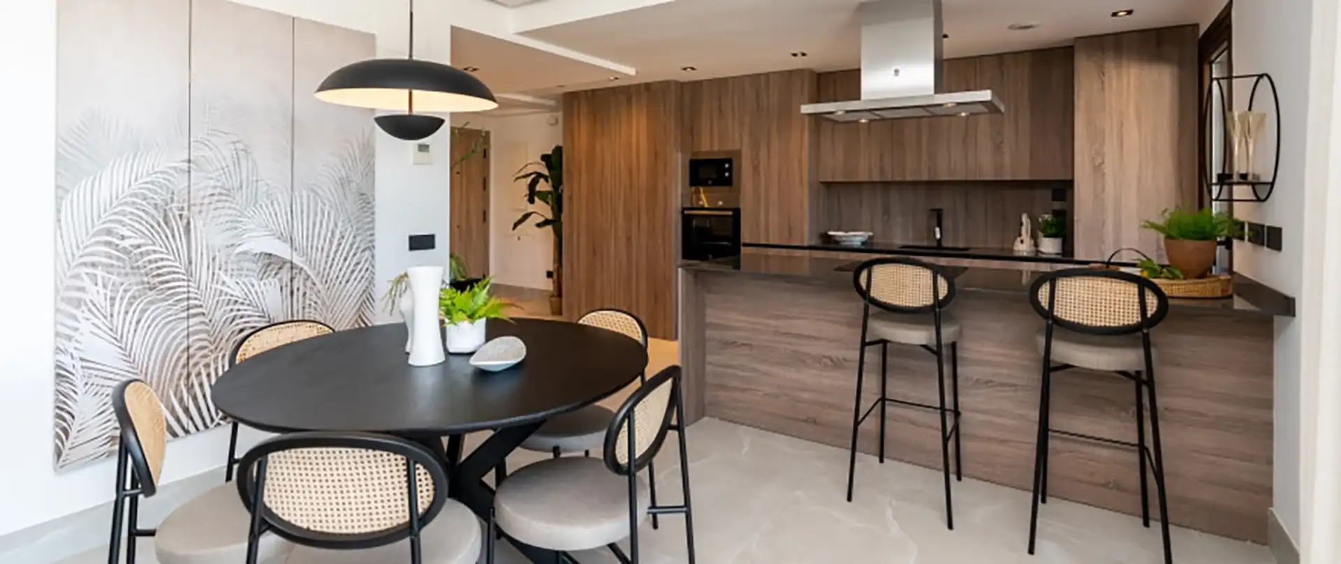 Modern open-plan kitchen and living area with wood finishes at Almazara Gardens Istán new development