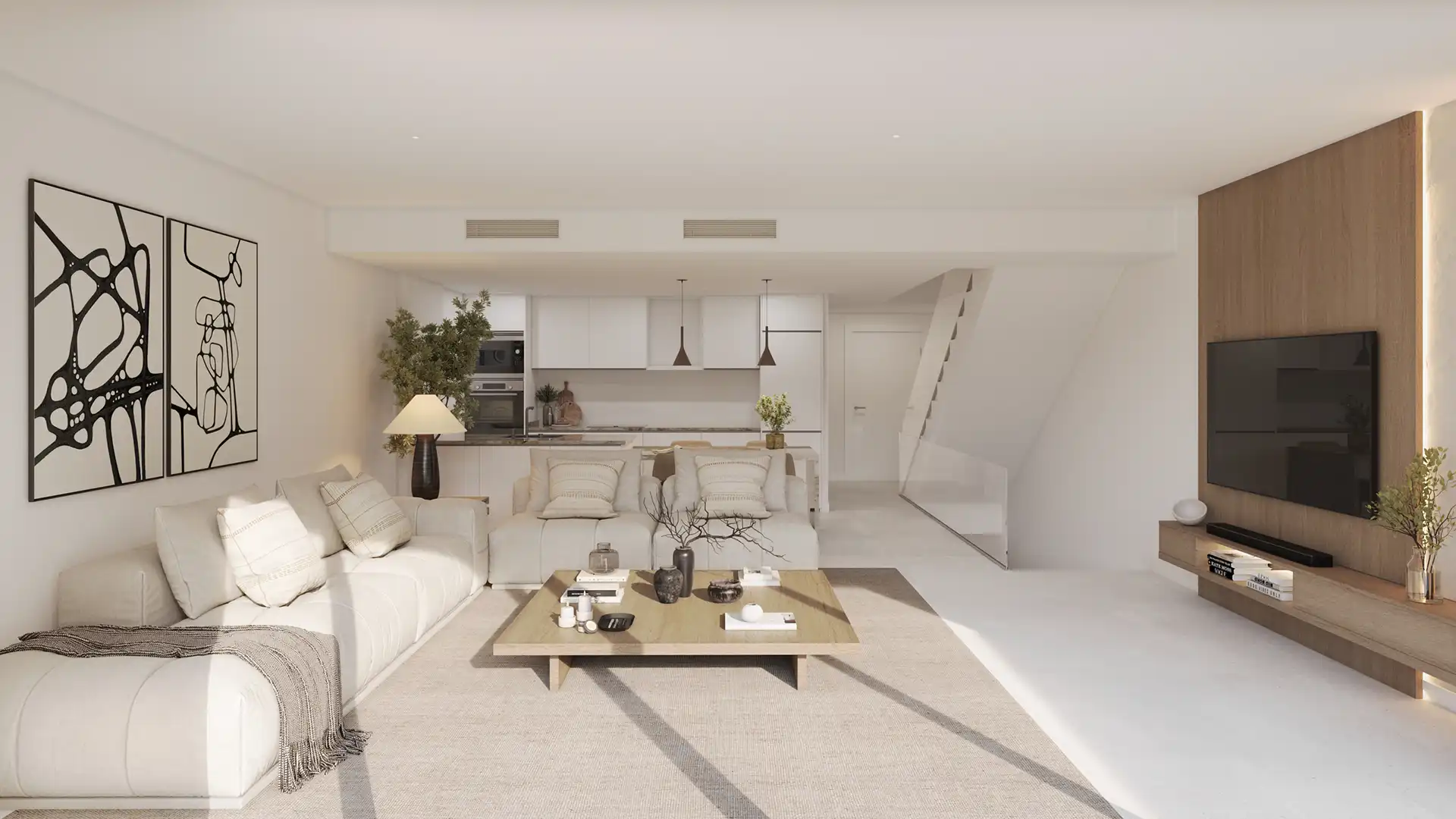 Modern open-plan living space with white kitchen and stairs in a luxury Fuengirola apartment
