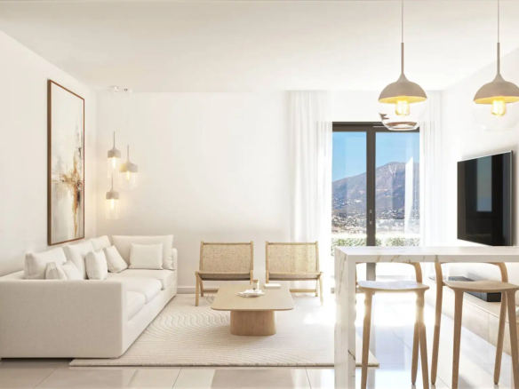 Elegant white open-plan living room with cream sofa, rattan chairs, marble kitchen island, and panoramic mountain view window