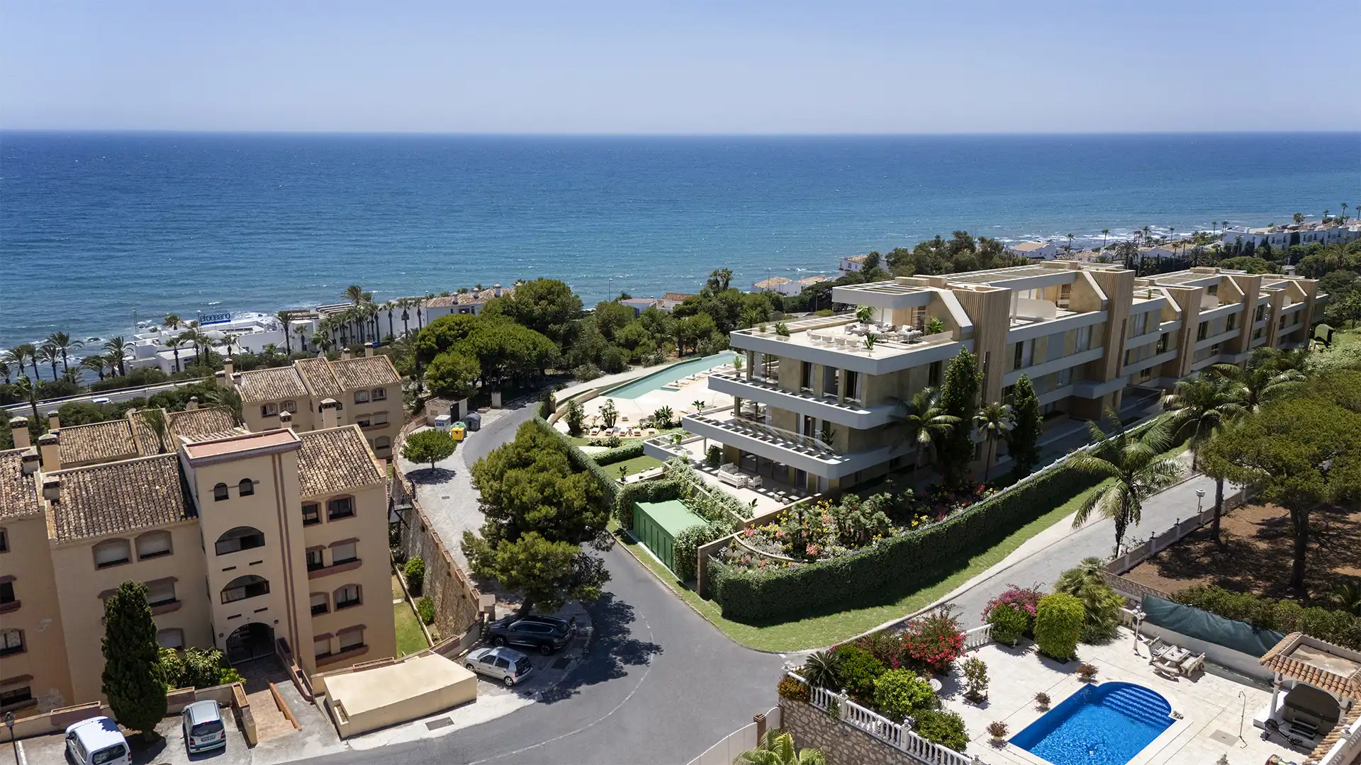 White contemporary apartment building at Arosa with curved balconies and palm trees in Torrenueva, Mijas
