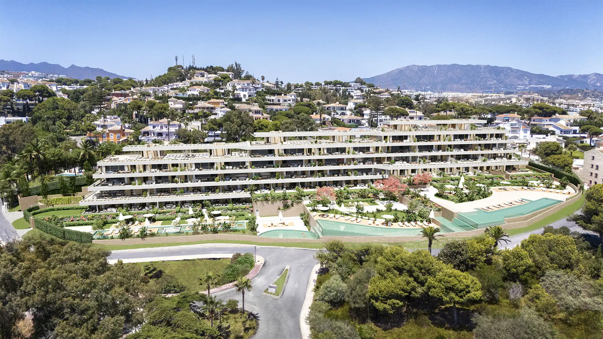 Communal swimming pool with sun loungers and landscaped gardens at a new Mijas Costa development