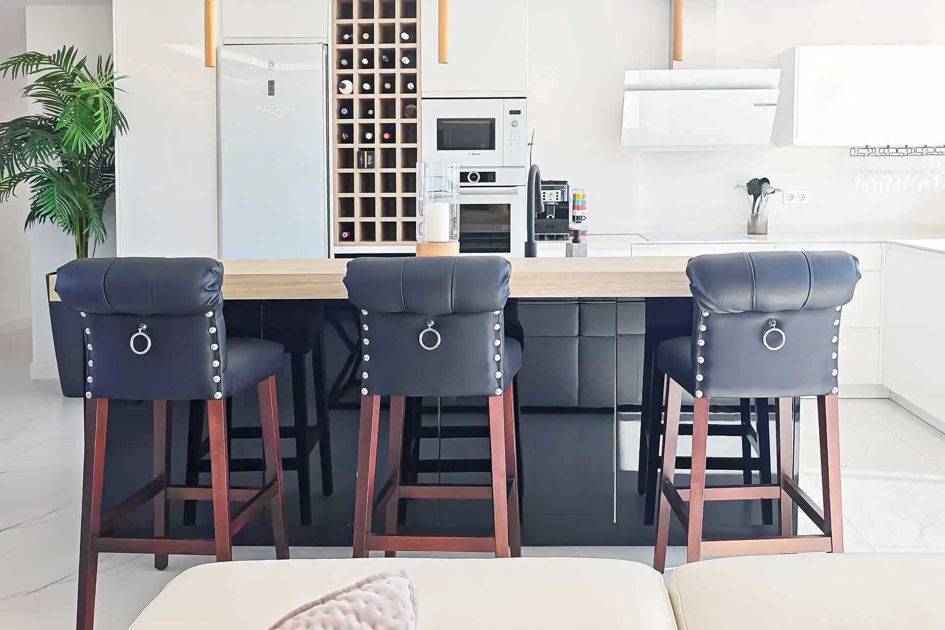 Modern kitchen island with bar stools and built-in appliances, Lotus Doña Julia penthouse